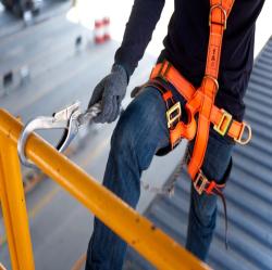 Construction worker hooked up to a safety harness